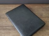a black leather case sitting on top of a wooden table