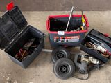 une boîte à outils contenant des outils, posée sur le sol