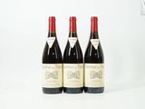 trois bouteilles de vin rouge posées sur une table blanche