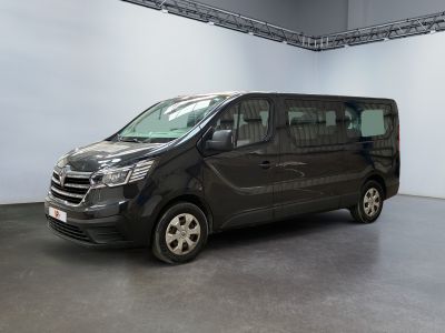 La camionnette noire est garée dans une grande pièce aux murs blancs.