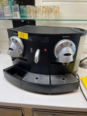 a black coffee machine sitting on a counter in a kitchen