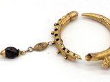 bracelet en or avec des perles noires et une perle noire sur fond blanc