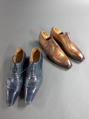 two pairs of men ' s shoes and a pair of shoes on a table