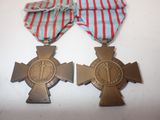 two medals are sitting on a white surface with a red and blue ribbon