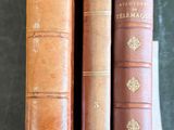 three old books sitting on top of a table next to each other