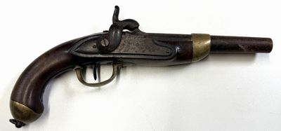 un vieux fusil exposé sur une surface blanche
