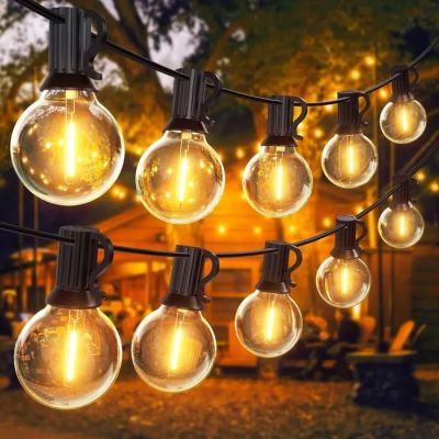 une guirlande d'ampoules suspendue à un arbre devant une cabane