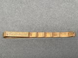 a close up of a gold bracelet on a gray surface