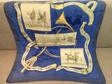 une image représentant un oreiller bleu orné d'une illustration représentant un cheval et son cavalier