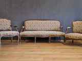 trois chaises et un canapé dans une pièce, avec un mur en arrière-plan