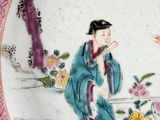 a plate with a painting of a woman and a bird on it