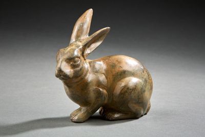 sculpture en bronze représentant un lapin sur un fond gris