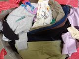 a basket full of clothes that is sitting on the floor