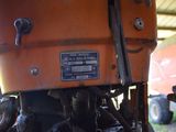 a close up of a tractor engine with a red truck in the background