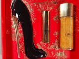 a red box with a pair of high heeled shoes and a bottle of perfume