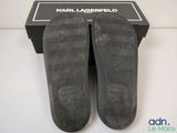 the soles of a pair of black slippers on a white surface