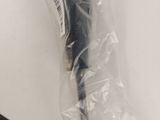 a black umbrella wrapped in plastic sitting on a table