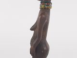 an image of a wooden statue of a man with a beaded collar