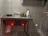 a kitchen with a sink, stove, and shelves in it