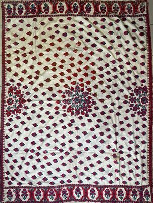 a white and red rug with a floral design on it