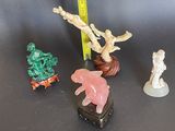 Plusieurs figurines de formes et de tailles variées sont posées sur une table
