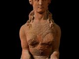 statue d'une femme tenant une boîte, les mains posées sur la poitrine