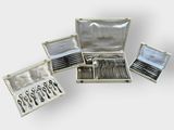 several silverware items are arranged in a silver box on a white surface