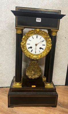 une horloge noire et dorée posée sur une table en bois