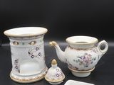 un service à thé et à café en porcelaine composé de trois pièces, posé sur un fond noir