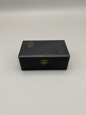 une vieille boîte noire posée sur une table blanche