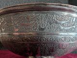 a large metal bowl sitting on a red cloth