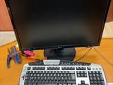 a computer keyboard and a monitor on a desk