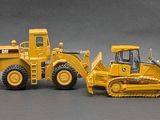 five toy construction vehicles lined up in a row