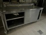 a large stainless steel counter in the middle of a kitchen