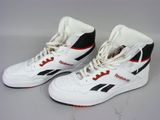 une paire de baskets blanches et noires avec des touches de rouge sur fond blanc