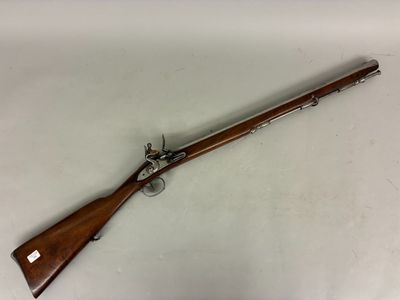 a rifle with a wooden handle on a white surface