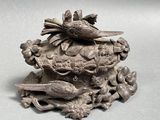 a bird sitting on top of a decorative object