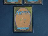 three decks of magic the gathering are on a black surface
