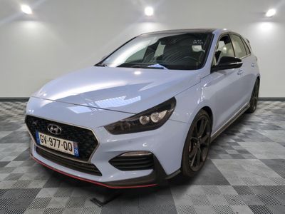 a white car parked in a garage with a checkered floor