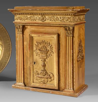 an image of a gold plate sitting next to a wooden cabinet