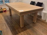 a wooden table in the middle of a room with two chairs