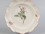 une assiette blanche ornée d'une rose rose