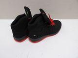 the pair of black and red shoes are sitting on a white surface