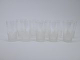 six verres transparents alignés les uns à côté des autres sur une surface blanche