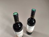 two bottles of wine sitting next to each other on a table
