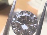 a close up of a diamond being held by a pair of pliers