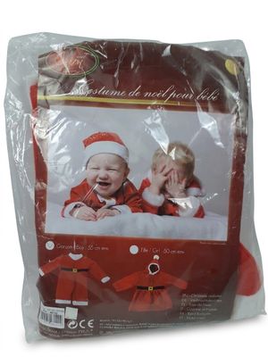 Le bébé porte un costume de Père Noël et un bonnet de Père Noël.