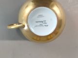 a gold cup with a handle on a white table