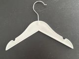 a close up of a white hanger on a black surface