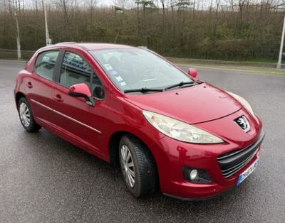 La voiture rouge est garée sur le bord de la route.